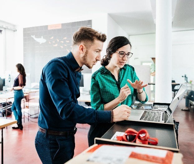 Co workers looking at a computer screen